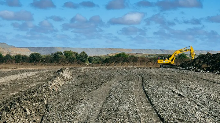 A construction site in a regional area highlights civil engineering efforts, with heavy machinery preparing roads as part of an infrastructure renewal project.