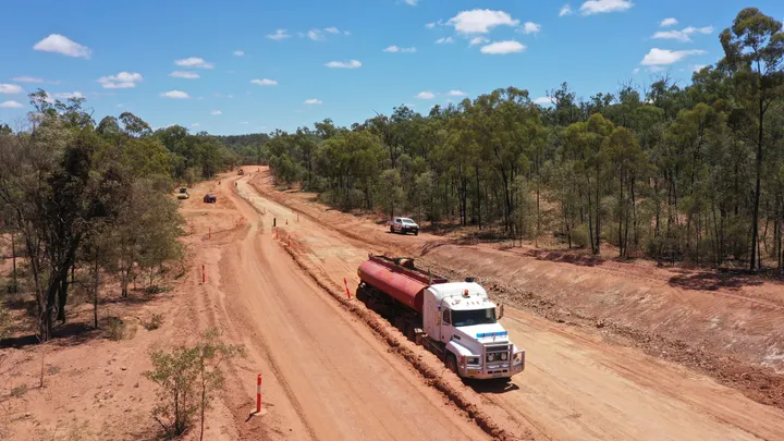 Heavy machinery flattening and compacting the road surface on Clermont Alpha Road during paving works