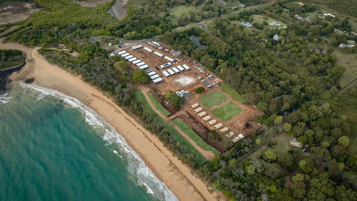 Aerial view of the Turtle Sands Holiday Park redevelopment project located in Mon Repos, Queensland, showcasing construction progress near the scenic beachfront and surrounding greenery.