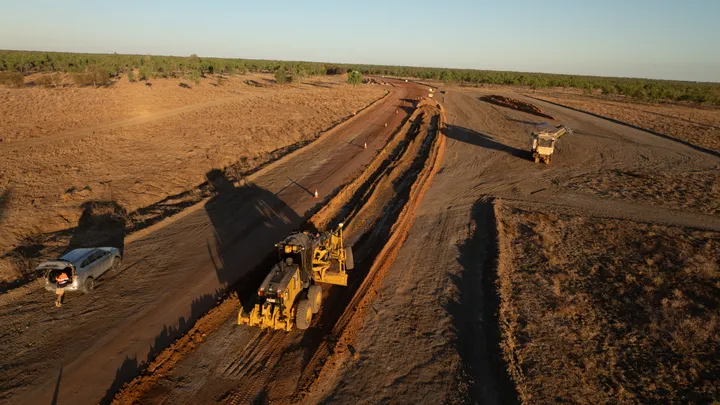 Grader and truck operating on a rural road construction site during earthworks