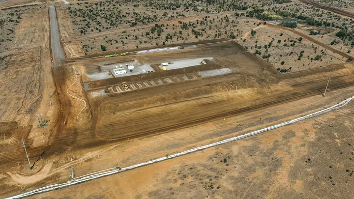 Aerial view of a construction site showcasing cleared land and early stages of civil engineering work, highlighting organised site management and infrastructure preparation in a remote area.