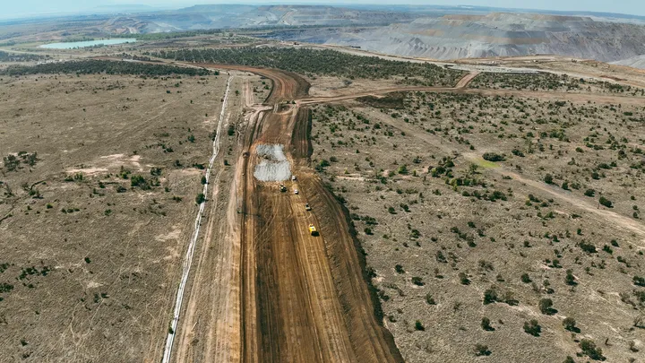 An aerial view of a large-scale infrastructure project highlights the development of rural roads, showcasing civil management efforts in a remote landscape.