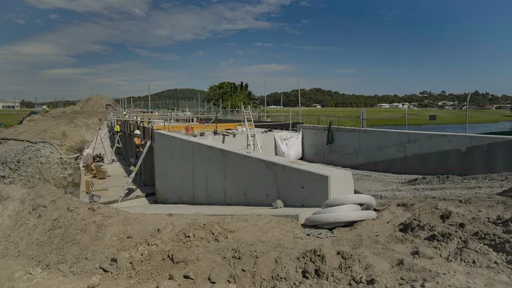 Gold Coast Airport infrastructure project featuring culvert demolition, new culvert construction, retaining walls, pavement works, and landscaping in progress.