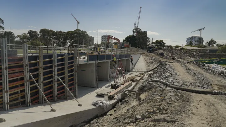 Workers constructing new culvert crossings with retaining walls and preparing for pavement works at Gold Coast Airport.
