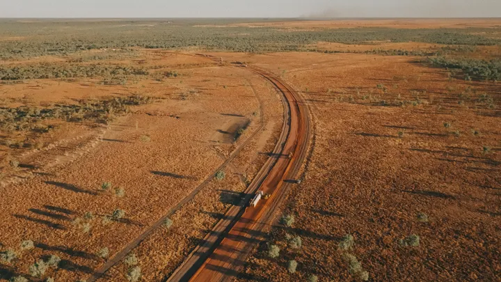 Wide view of a road construction project stretching through rural land, with machinery working on the site.