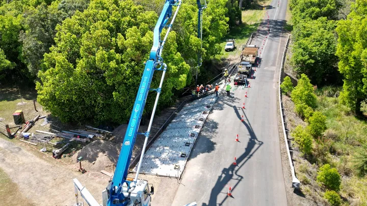 A wide-angle shot of road construction with concrete pumping in progress, highlighting Durack Civil's work on Gympie Regional Council's Resilience and Recovery under the Disaster Recovery Funding Arrangements