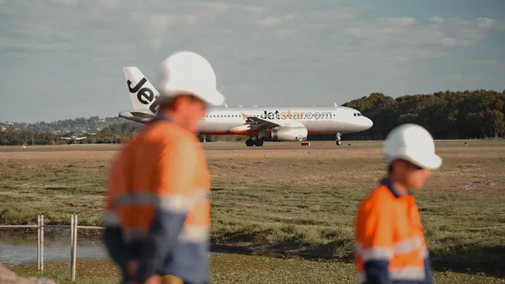 Construction workers in high-visibility gear at Gold Coast Airport, completing a infrastructure project